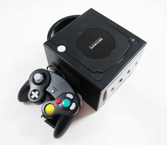 Black Nintendo GameCube top view with circular disc cover and matching third-party controller.