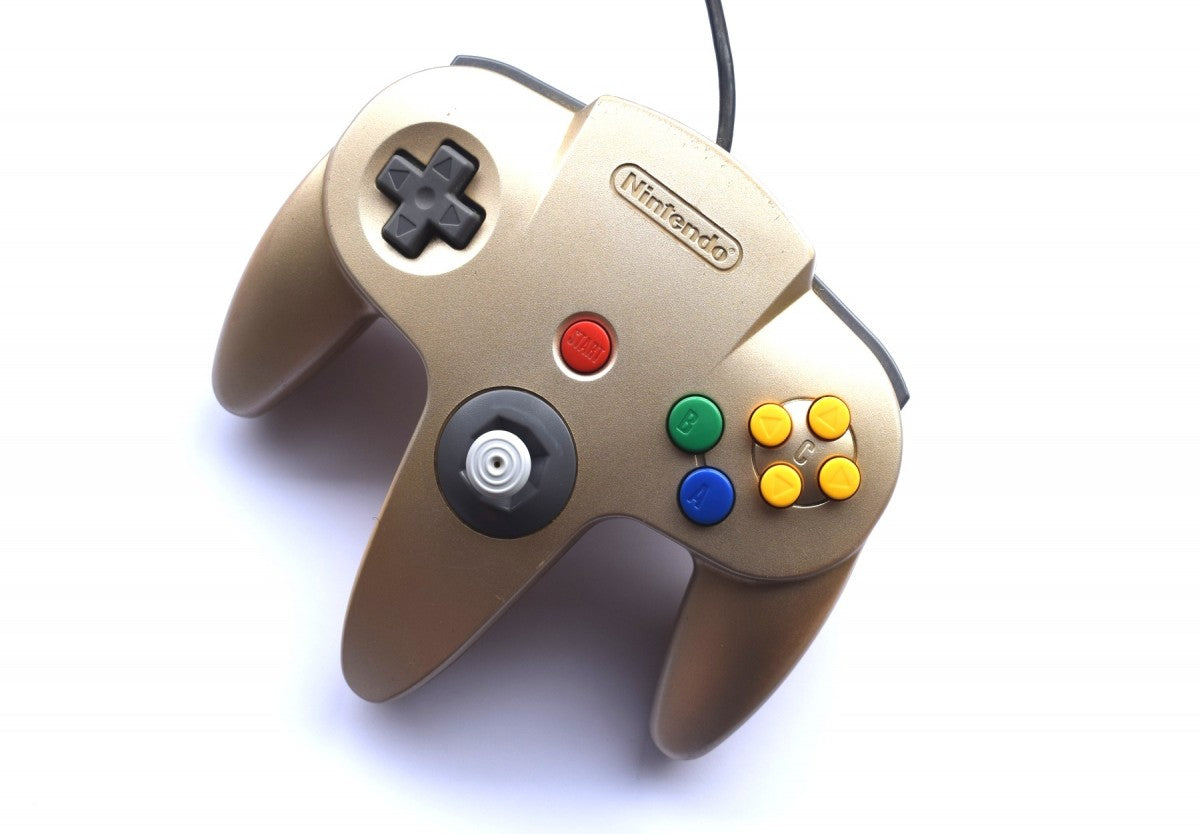 Top view of the gold Nintendo 64 controller, showing joystick, D-pad, action buttons, and overall ergonomic design for gameplay