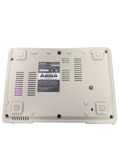 Bottom view of a classic Sony PlayStation 1 console showing screw placements, vents, and label details.