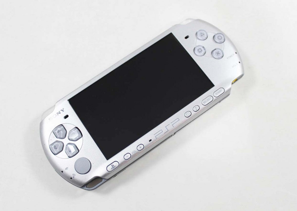 PlayStation Portable PSP 3000 Silver handheld console for video game enthusiasts featuring portable gaming hardware vibrant widescreen display built in stereo speakers ergonomic handheld design UMD game compatibility multimedia entertainment and collectible gaming appeal top angle  