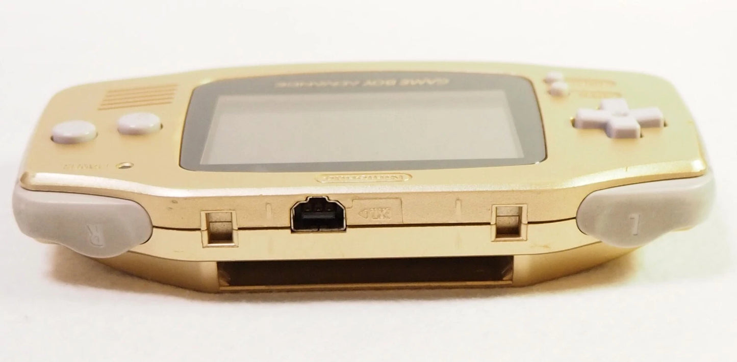 Top-down view of a gold Game Boy Advance console showing the cartridge slot opening along the top edge of its metallic casing.
