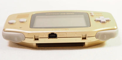 Top-down view of a gold Game Boy Advance console showing the cartridge slot opening along the top edge of its metallic casing.