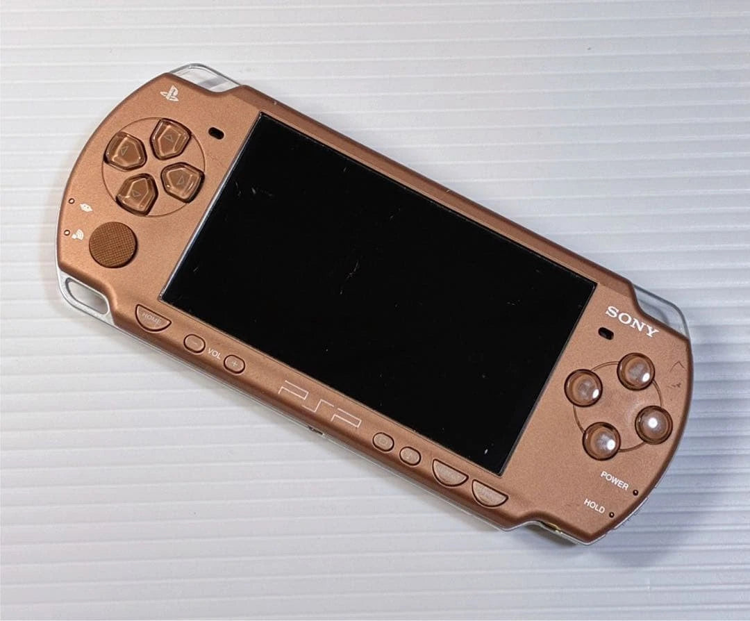 Bronze PlayStation Portable 2000 PSP 2000 handheld gaming console featuring metallic bronze finish portable Sony gaming UMD game support Memory Stick storage widescreen LCD display built-in controls rechargeable battery classic PSP hardware and collectible gaming appeal front of console