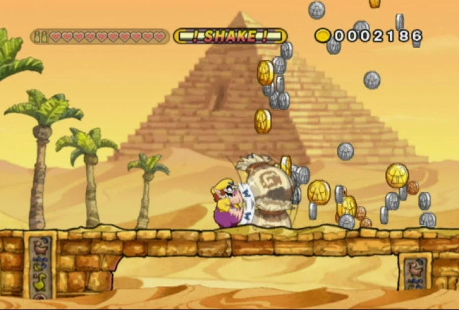 Wario Land: Shake It gameplay for Nintendo Wii (Wii) featuring side‑scrolling platform action with hand‑drawn animation, treasure hunting, and motion‑controlled shaking mechanics.