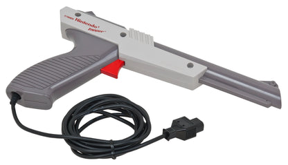 OEM Nintendo Zapper light gun accessory in gray for the Nintendo Entertainment System NES official authentic peripheral with orange tip trigger grip and cable connector for Duck Hunt and other shooting games right side aim down