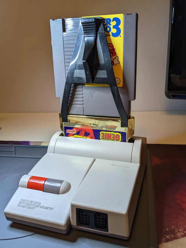 Game Genie for Nintendo Entertainment System (NES) at Gamers INC, featuring the legendary cheat-code breakthrough that unlocked a new dimension of gaming by allowing players to enter alphanumeric codes to bypass difficult levels, gain infinite lives, or discover hidden game features; this essential accessory includes the classic gold cartridge design and provides the ultimate power-up for your entire NES library, from Super Mario Bros. to The Legend of Zelda plugged in NES