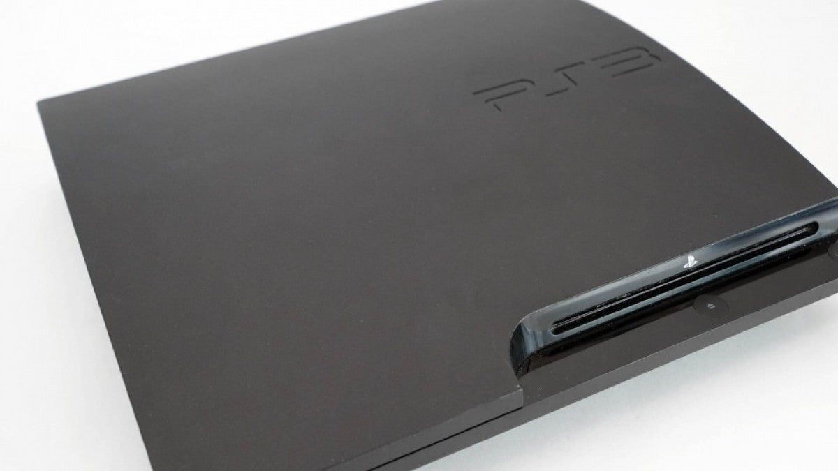 Angled front view of a Sony PS3 Slim console showing the disc slot, power and eject buttons, logo, and top surface from a slight side perspective.