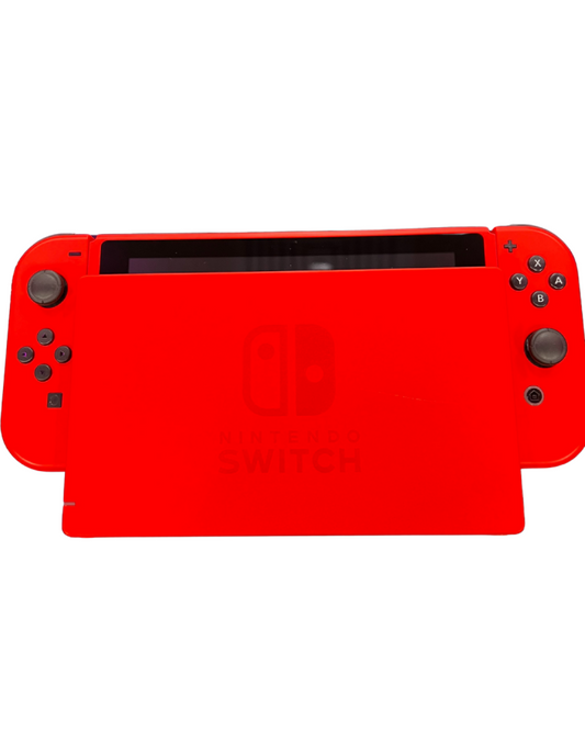 Front view of the red Mario Edition Nintendo Switch console seated in its matching red dock with Joy-Con controllers attached.