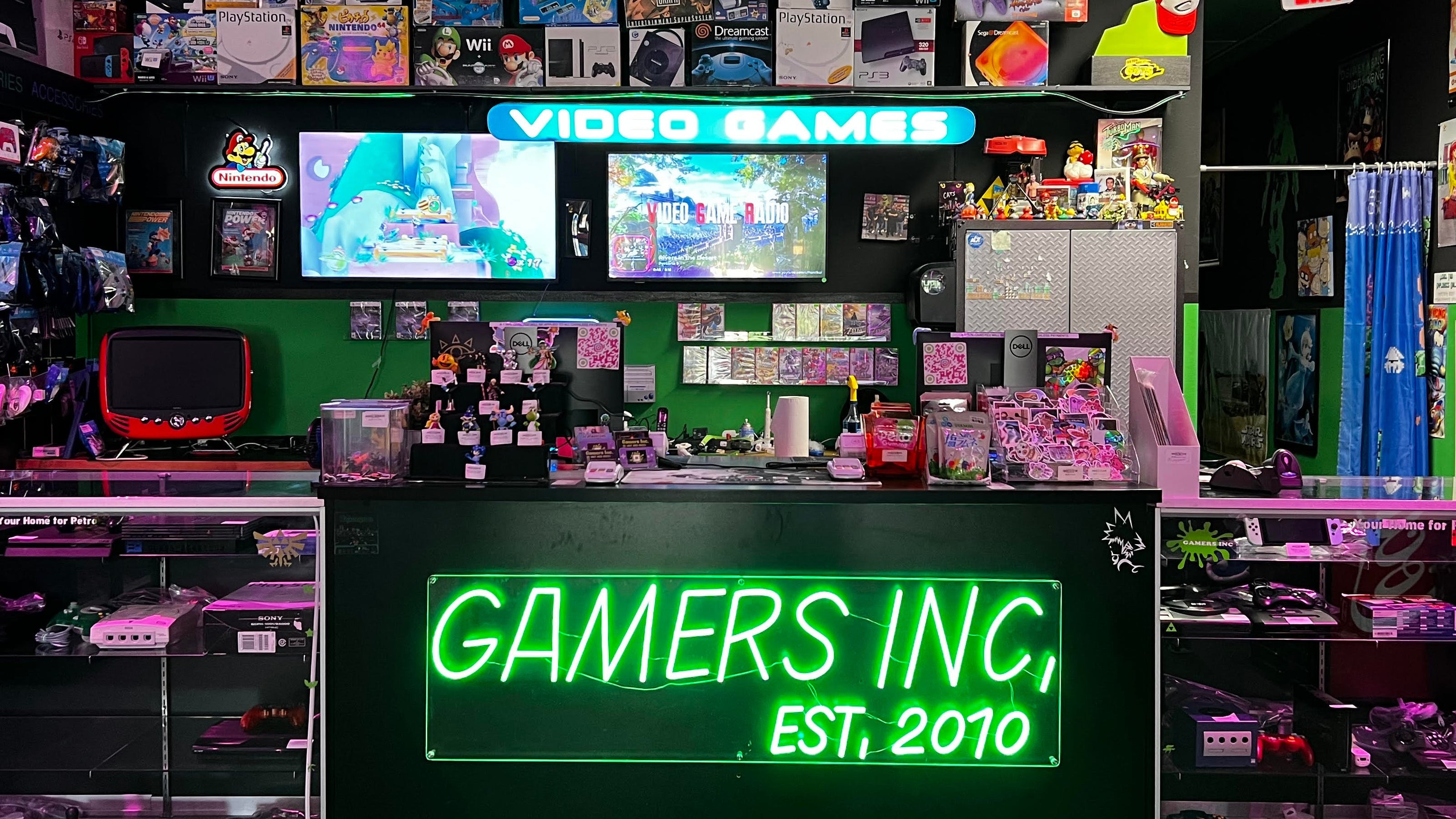 Video game store interior with 'GAMERS INC' sign and gaming equipment at Gamers Inc Orlando Gamers Go Retro